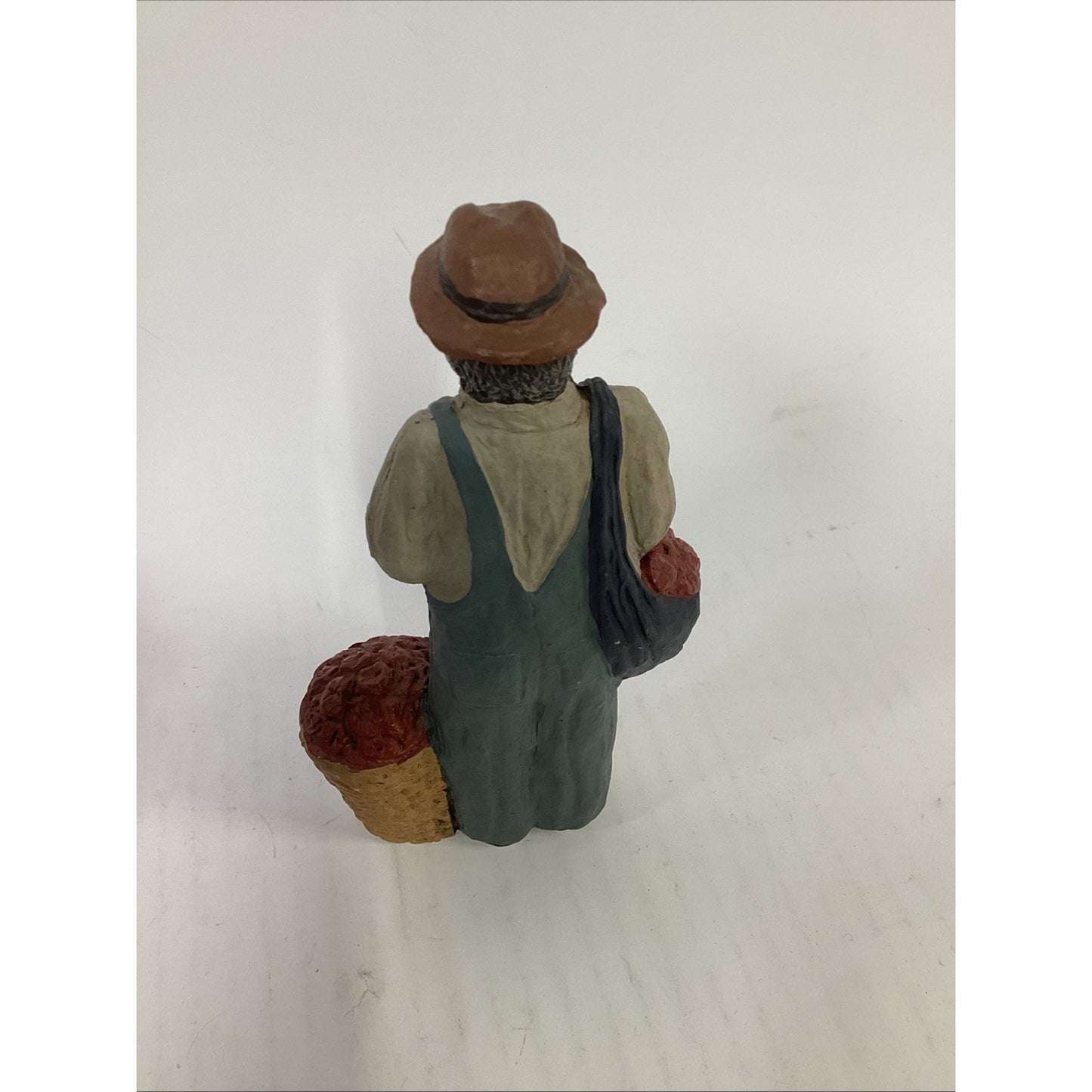 BLACK FARMER STATUE WEARING A HAT AND CARRYING FOOD BASKETS