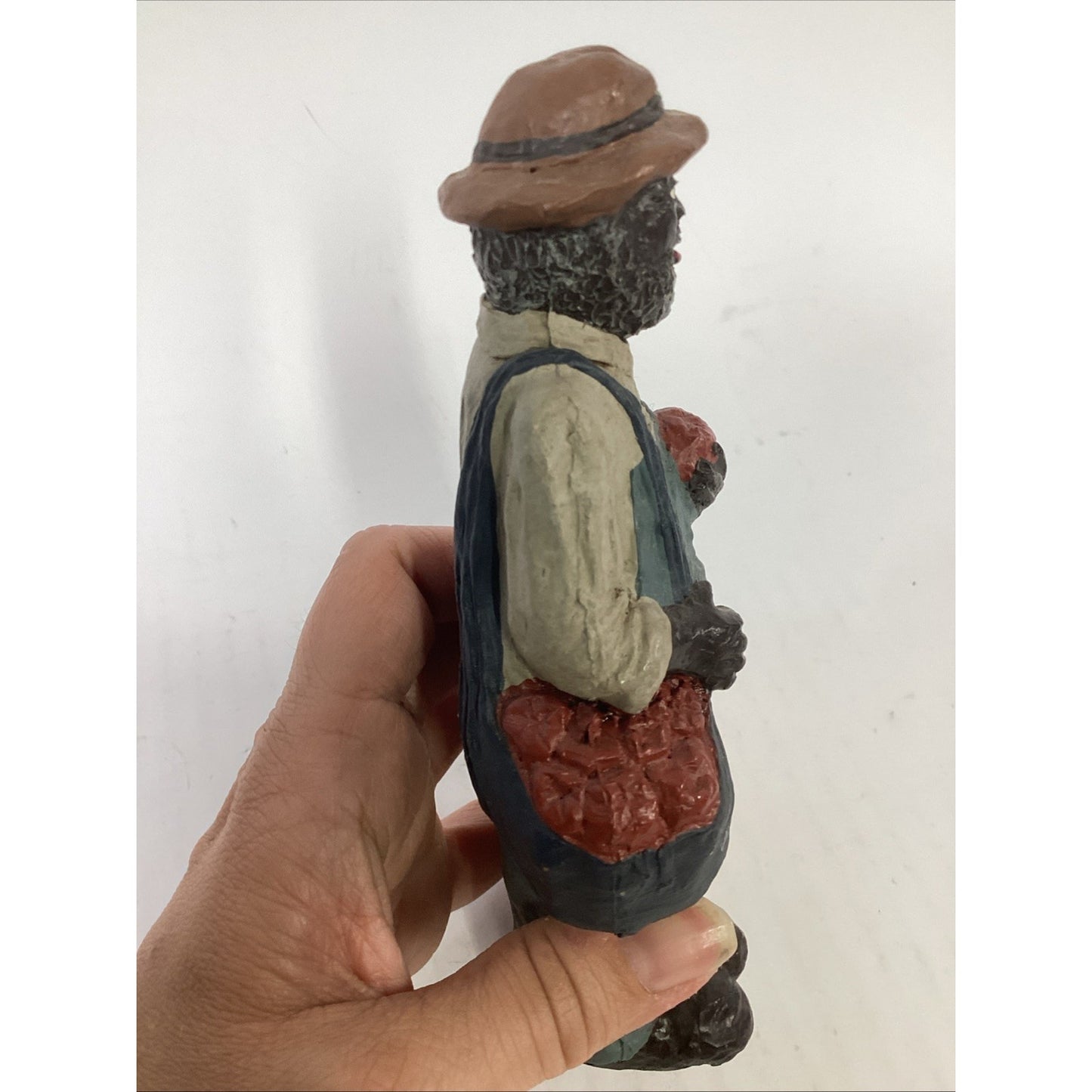 BLACK FARMER STATUE WEARING A HAT AND CARRYING FOOD BASKETS