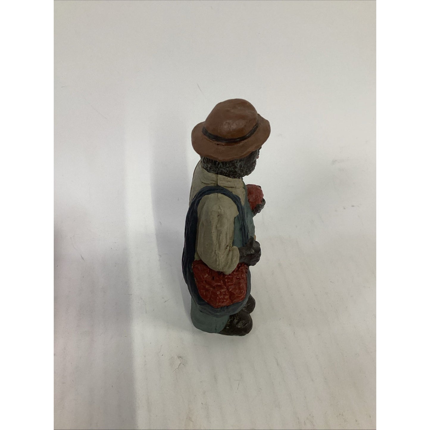 BLACK FARMER STATUE WEARING A HAT AND CARRYING FOOD BASKETS