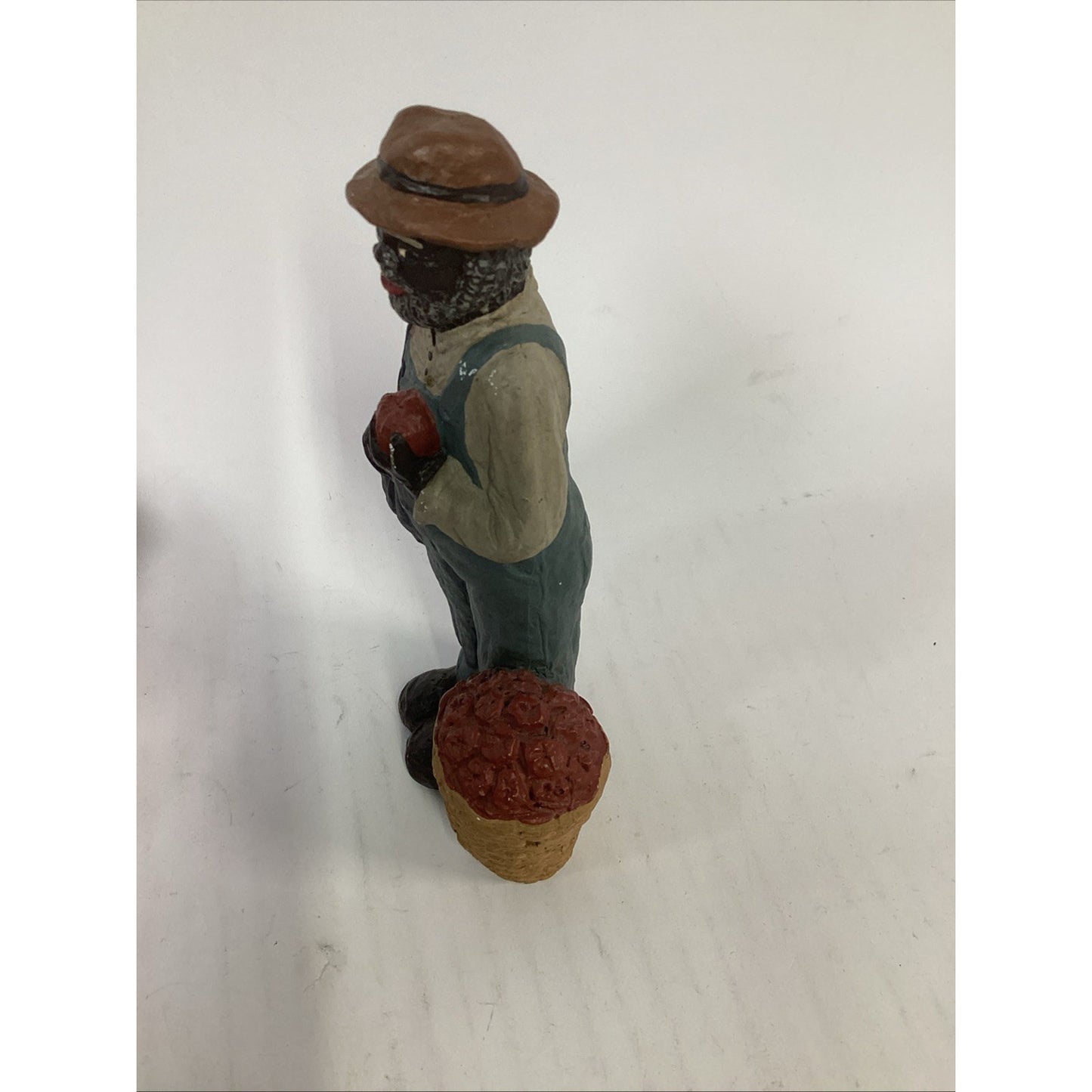 BLACK FARMER STATUE WEARING A HAT AND CARRYING FOOD BASKETS
