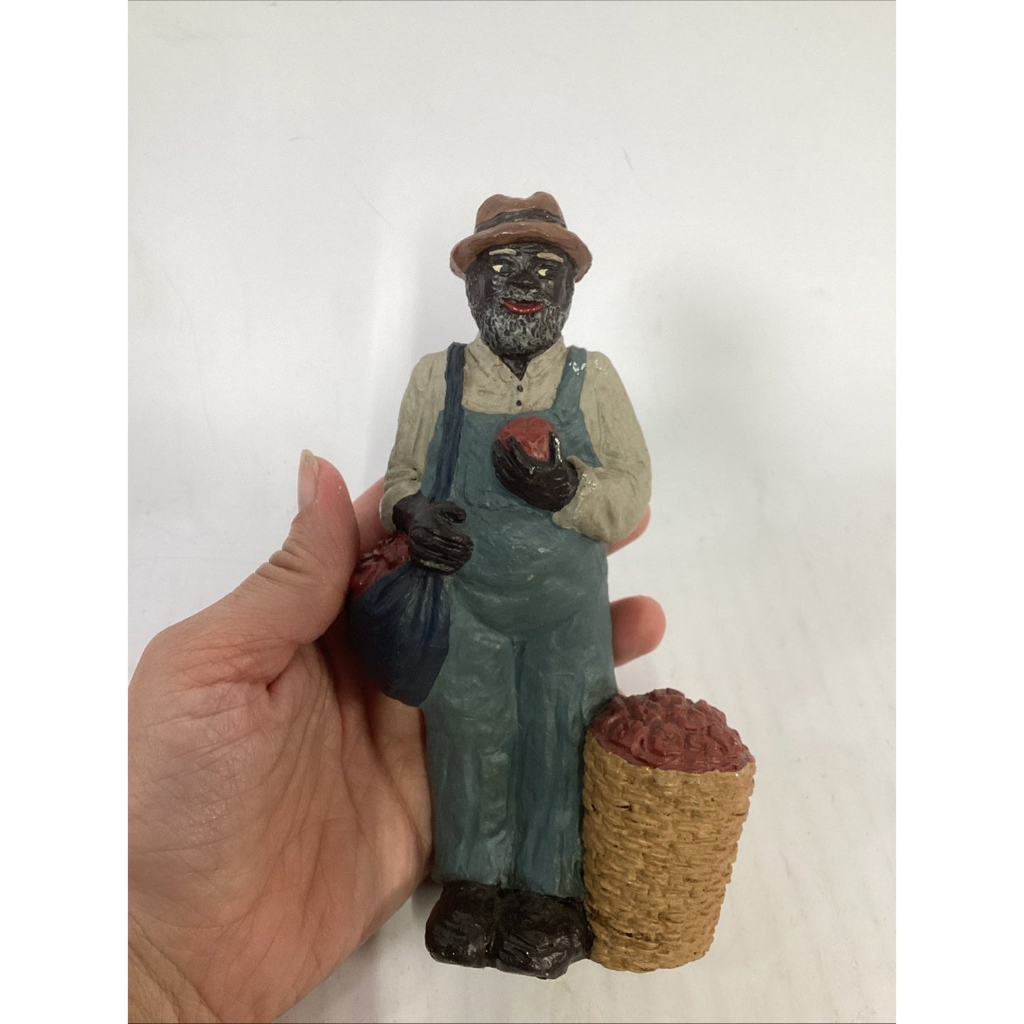 BLACK FARMER STATUE WEARING A HAT AND CARRYING FOOD BASKETS